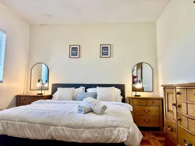 a bedroom with a large bed with two dressers and two mirrors at Lujosa Y Acogedora Casa En Miami! in Tamiami