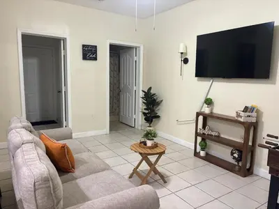 a living room with a couch and a flat screen tv at Lujosa Y Acogedora Casa En Miami! in Tamiami