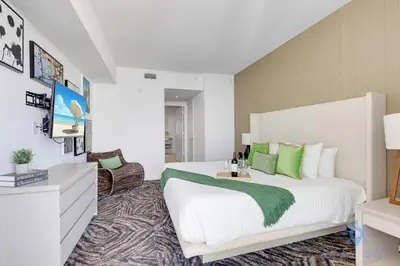a bedroom with a large white bed with green pillows at Cozy Apartment with Balcony in Hollywood