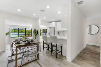 a kitchen and dining room with a table and chairs at Charming 4BR Oasis with Saltwater Pool and Parking in North Miami