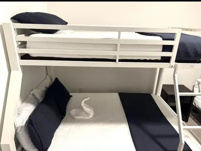 two bunk beds in a small room with a bed at Cozy house in Goulds