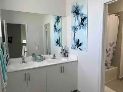 a bathroom with two sinks and a large mirror at Cozy house in Goulds