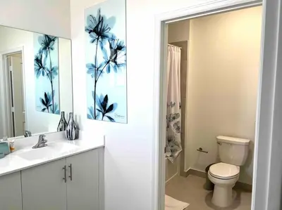 a bathroom with a toilet and a sink and a mirror at Cozy house in Goulds