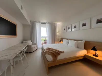 a bedroom with a bed and a desk and a television at Luxury Ocean Views Apt in Hallandale Beach in Hallandale Beach