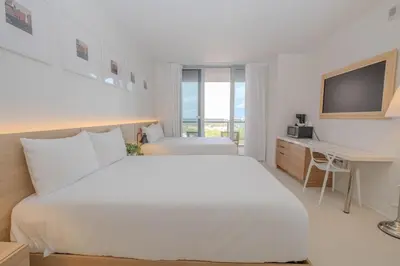 a white bedroom with a large bed and a desk at Studio Luxury Ocean Views Apt in Hallandale Beach in Hallandale Beach