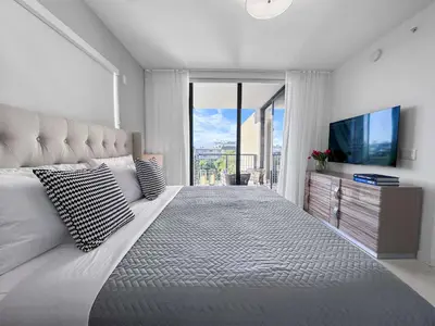a bedroom with a large bed with a large window at Bay Breeze Premium Apartments by Eskape Collection in Miami Beach
