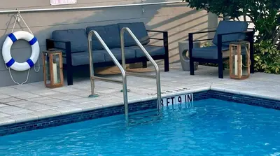a swimming pool with two chairs and a swimming pool at Bay Breeze Premium Apartments by Eskape Collection in Miami Beach