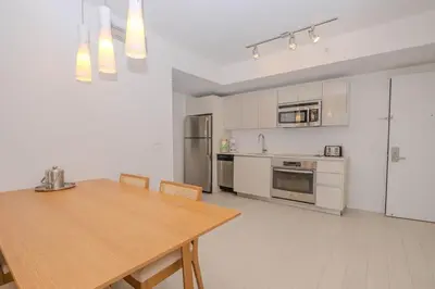 a kitchen with a wooden table and a kitchen with appliances at 2B 2B Luxury Ocean Views Apt in Hallandale Beach in Hallandale Beach