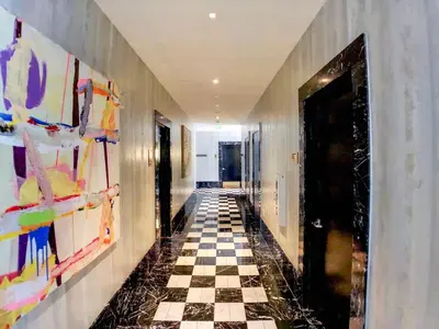 a hallway with a checkered floor and paintings on the walls at High Ceiling Exquisite 1BR 1BA ICON Brickell in Miami