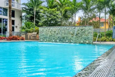 a swimming pool with blue water and palm trees at Trendy One Bedroom Getaway Steps from Biscayne in Miami