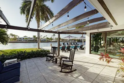 a patio with chairs and a table with a view of the water at Palm Pointe - One third of a mile to the beach - Heated Pool - Intracoastal Views in Fort Lauderdale