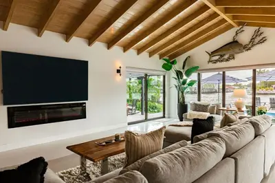 a living room with a large couch and a flat screen tv at Palm Pointe - One third of a mile to the beach - Heated Pool - Intracoastal Views in Fort Lauderdale