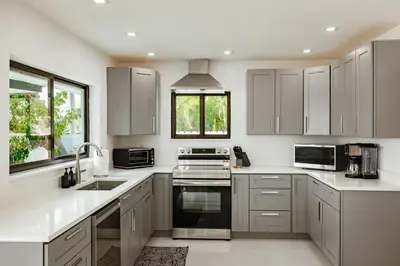 a kitchen with white cabinets and a sink at Palm Pointe - One third of a mile to the beach - Heated Pool - Intracoastal Views in Fort Lauderdale