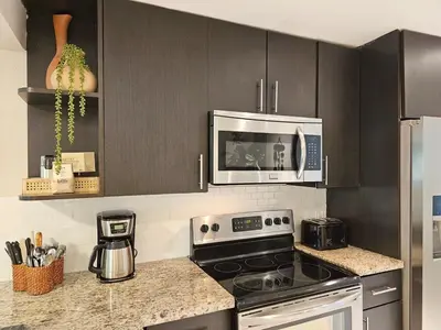 a kitchen with a stove and a microwave at Casa Eden - Half mile to Lauderdale Marine Center - 4 bedrooms - 2 bathrooms in Fort Lauderdale