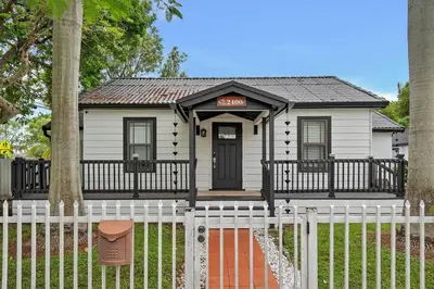 a small white house with a sign on it at Casa Del Sol Cozy 2br Retreat 10 Mins To Beach in Miami