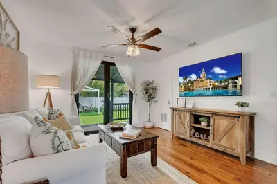 a living room with a white couch and a ceiling fan at Casa Del Sol Cozy 2br Retreat 10 Mins To Beach in Miami