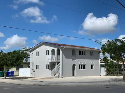 a white building with a balcony on a street at Stylish 2 Bedrooms Apartment by Miami Airport in Miami