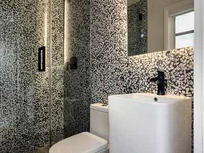 a bathroom with a toilet and a sink and a mirror at Stunning 8 bedroom Villa with Pool Basketball Pickleball BBQ Mini-golf and more in North Miami