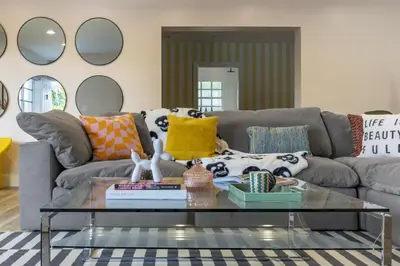a living room with a couch and a glass table at Stunning 8 bedroom Villa with Pool Basketball Pickleball BBQ Mini-golf and more in North Miami