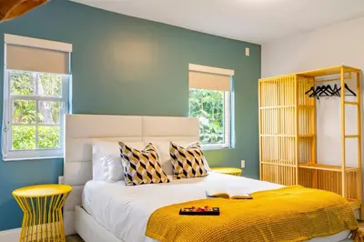 a bedroom with a large bed with a yellow blanket at Stunning 8 bedroom Villa with Pool Basketball Pickleball BBQ Mini-golf and more in North Miami