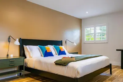 a bedroom with a bed with blue and orange pillows at Villa Tation 8BR Mini Hotel in Plantation