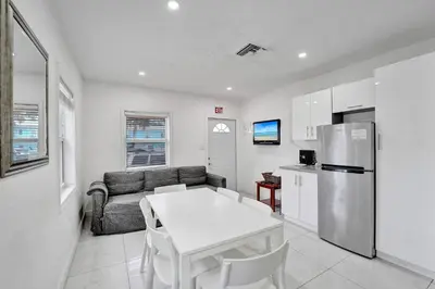 a kitchen and living room with a table and a refrigerator at Seaside Beach House in Hollywood