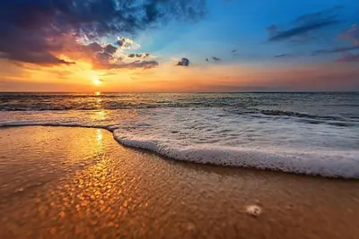 a sunset on a beach with the ocean at Beach Breeze Suite - Steps to the Beach in Hollywood