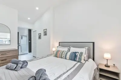 a white bedroom with a large bed and a mirror at Casa Belle 3br W Pool & Bbq 10 Mins To Beach in Miami