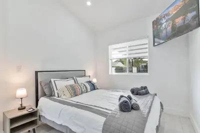 a white bedroom with a bed with shoes on it at Casa Belle 3br W Pool & Bbq 10 Mins To Beach in Miami