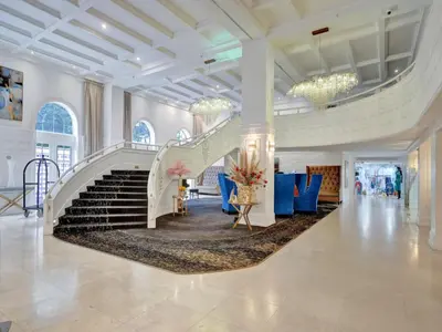 a lobby with a staircase and blue chairs at Lovely 2BR condo with Resort Access, Gym and Pool 1608 in Miami Beach