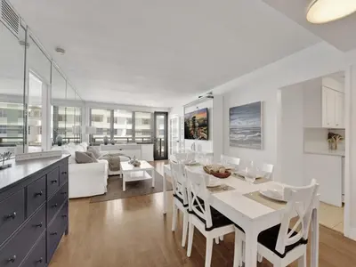 a kitchen and living room with a white table and chairs at Lovely 2BR condo with Resort Access, Gym and Pool 1608 in Miami Beach
