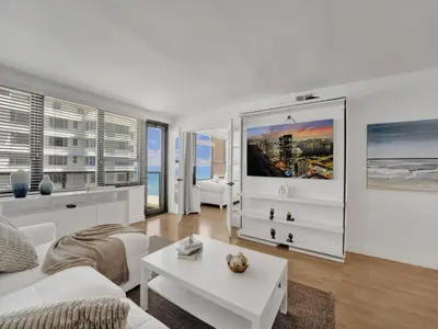 a white living room with a white couch and a table at Lovely 2BR condo with Resort Access, Gym and Pool 1608 in Miami Beach