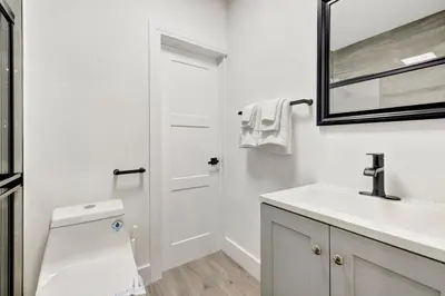 a white bathroom with a sink and a mirror at Banyan St. 1BR 1BA off Las Olas - Steps to Beach in Fort Lauderdale