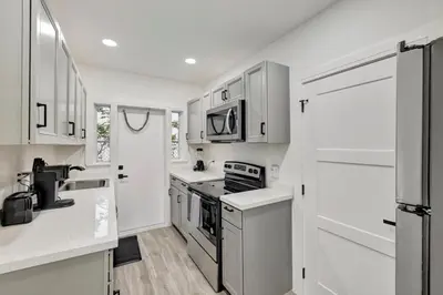 a kitchen with white cabinets and stainless steel appliances at Banyan St. 1BR 1BA off Las Olas - Steps to Beach in Fort Lauderdale
