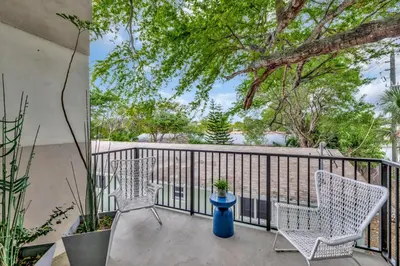 a balcony with two chairs and a blue vase at 3BR 2.5BA Townhome-10 mins to FTL Beach and Downtown in Fort Lauderdale