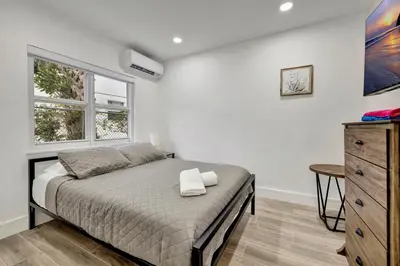 a bedroom with a bed and a dresser and a window at Banyan St 2BR 1BA off Las Olas- Steps to Beach unit 4 in Fort Lauderdale