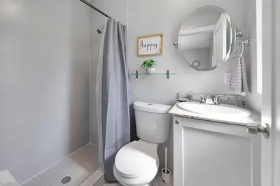 a bathroom with a toilet and a sink and a mirror at Comfy & Spacious Duplex w Top Amenities! in Miami