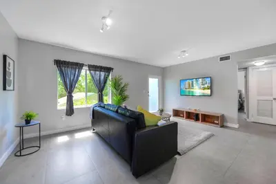 a living room with a couch and a tv at Comfy & Spacious Duplex w Top Amenities! in Miami
