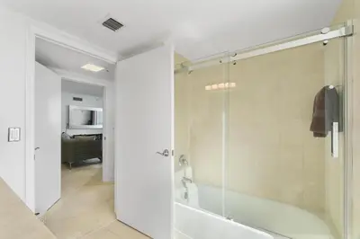 a bathroom with a shower with a glass door at Luxurious 2BD Condo with Direct Ocean Front & Resort Pool in Sunny Isles in Sunny Isles Beach