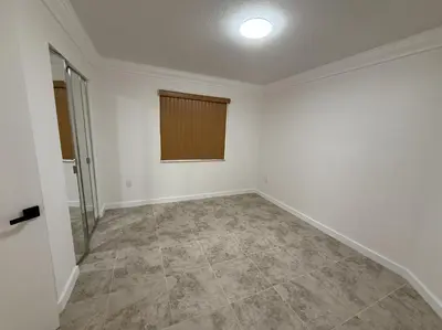 an empty room with white walls and tile floors at 1644 Jackson St, Hollywood, FL 33020 in Hollywood