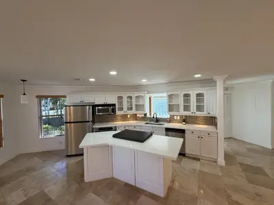 a large kitchen with white cabinets and a counter top at 1644 Jackson St, Hollywood, FL 33020 in Hollywood