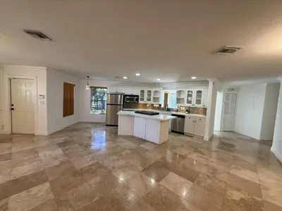 a large kitchen with white cabinets and a tile floor at 1644 Jackson St, Hollywood, FL 33020 in Hollywood