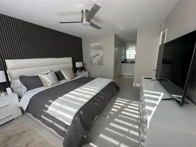 a bedroom with a large bed and a flat screen tv at Urban Luxe Aventura 22 Retreat in Aventura
