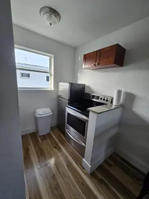 a small kitchen with a stove and a refrigerator at Cozy Place Near Design District - 4 in Miami