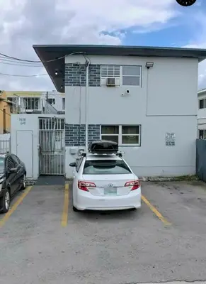 a white car parked in a parking lot in front of a building at Cozy Place Near Design District - 4 in Miami