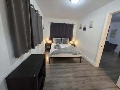 a bedroom with a bed with two lamps and a table at Cozy Place Near Design District - 3 in Miami