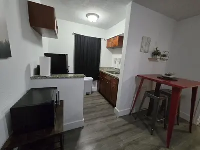 a small kitchen with a small table and a room with a tableablish at Cozy Place Near Design District - 3 in Miami