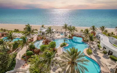 an aerial view of a resort with a swimming pool and the beach at Unique Apartment Miami Views in Sunny Isles Beach