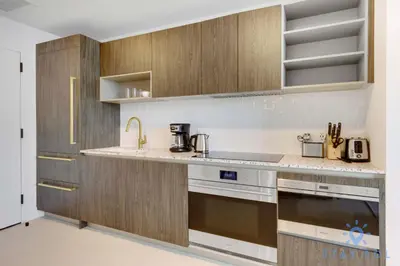 a kitchen with wooden cabinets and a stove top oven at 1 BR - City Views Gym & Pool in Miami