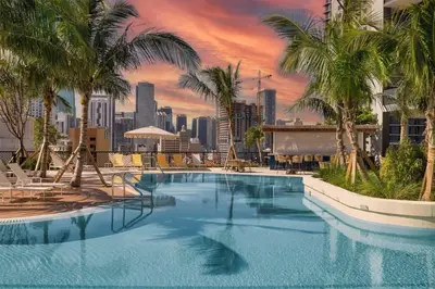 a large pool with palm trees and a city skyline at 1 BR - City Views Gym & Pool in Miami